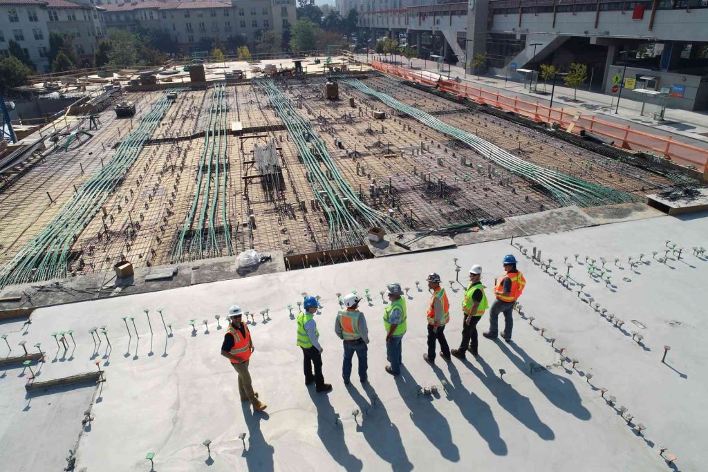 sept ouvriers du bâtiment debout sur un champ blanc